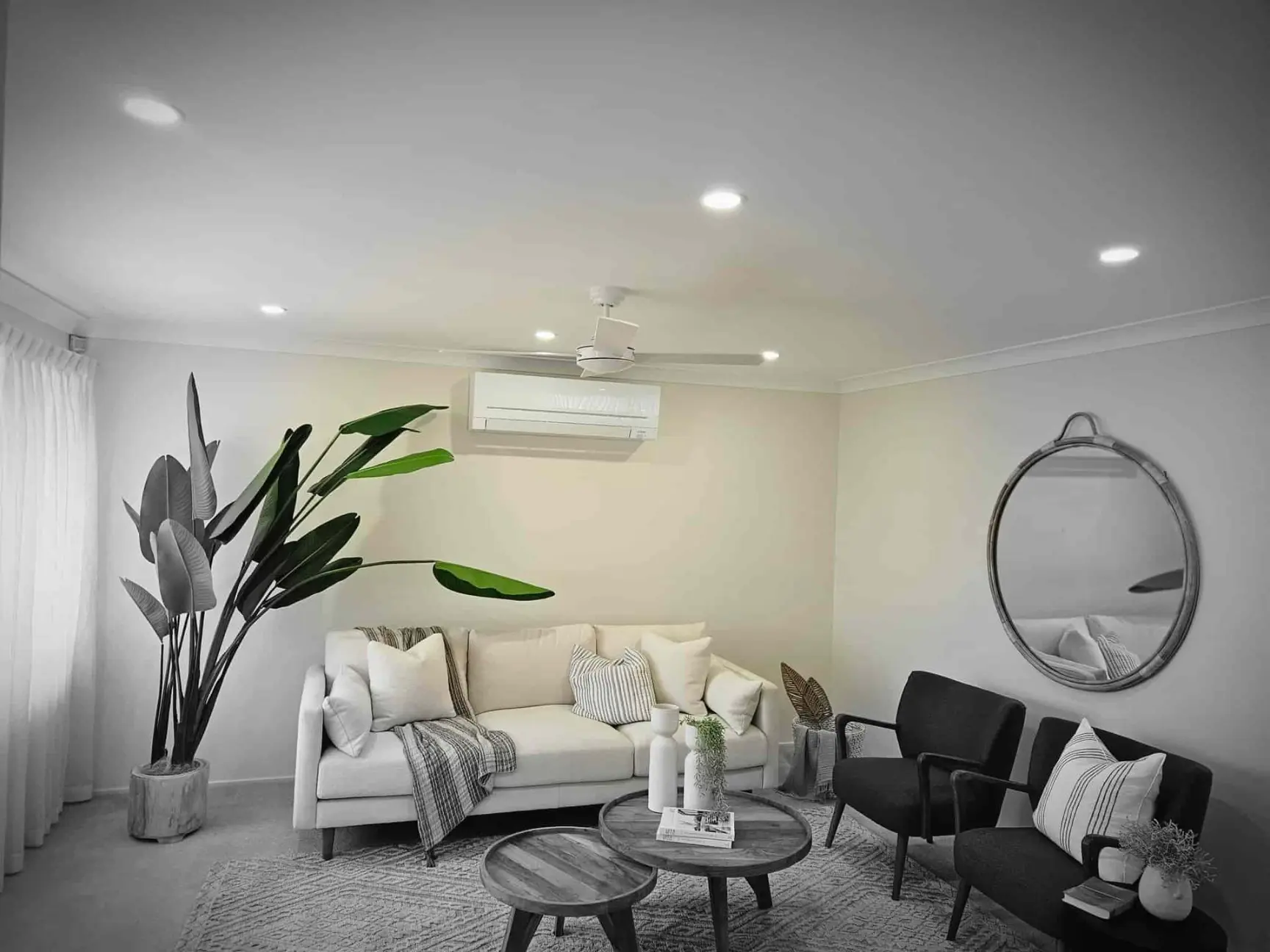 Styled living room with LED downlights, a ceiling fan and a split-system air conditioner
